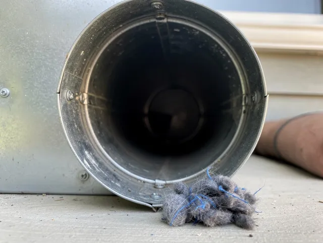 Redlands Dryer Vent Cleaning technician using specialized equipment to clear severe dryer vent blockage in Redlands